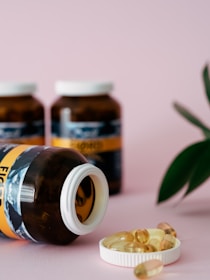 a close up of a bottle of pills next to a plant