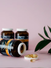 A bottle of Nourish Crown Capsules surrounded by fresh herbs on a cream background.
