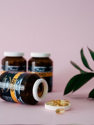 Bottles of herbal supplements with capsules spilling out, set against a backdrop of natural herbs.