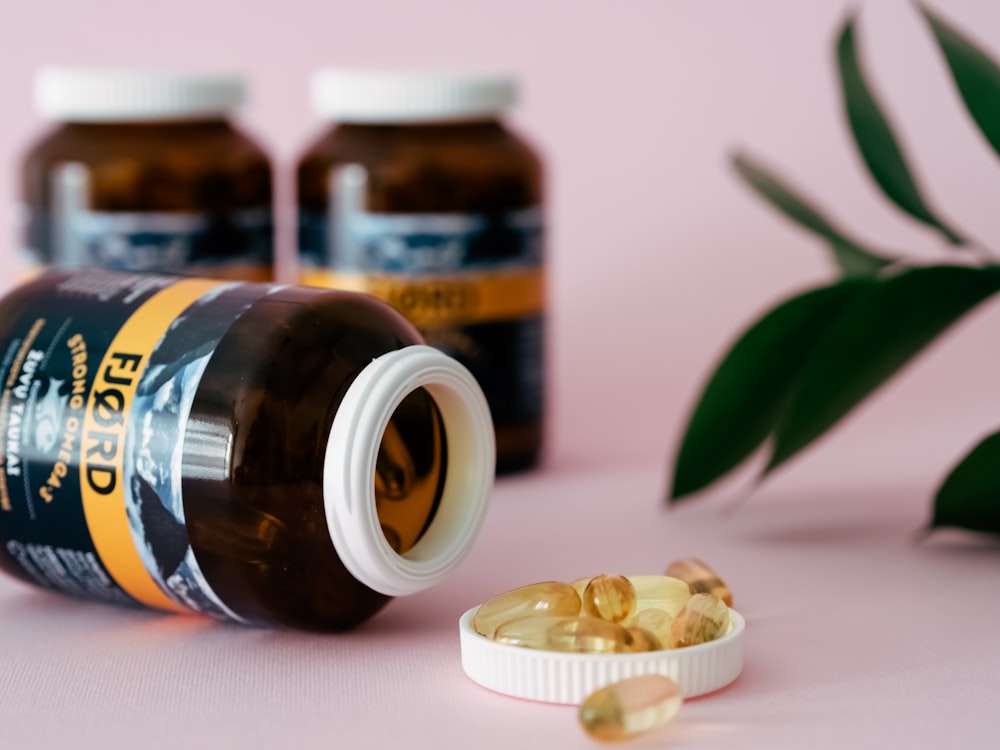 a close up of a bottle of pills next to a plant