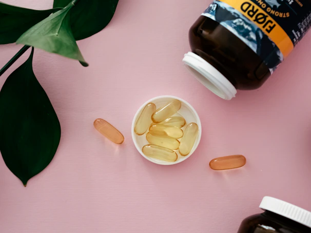 Prodentim capsules spilling out of the bottle on a wooden surface with green leaves