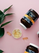 three bottles of vitamins sitting on top of a pink surface