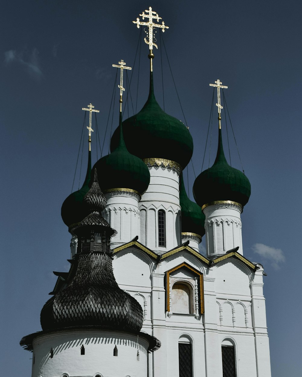 a white church with green domes and crosses on top