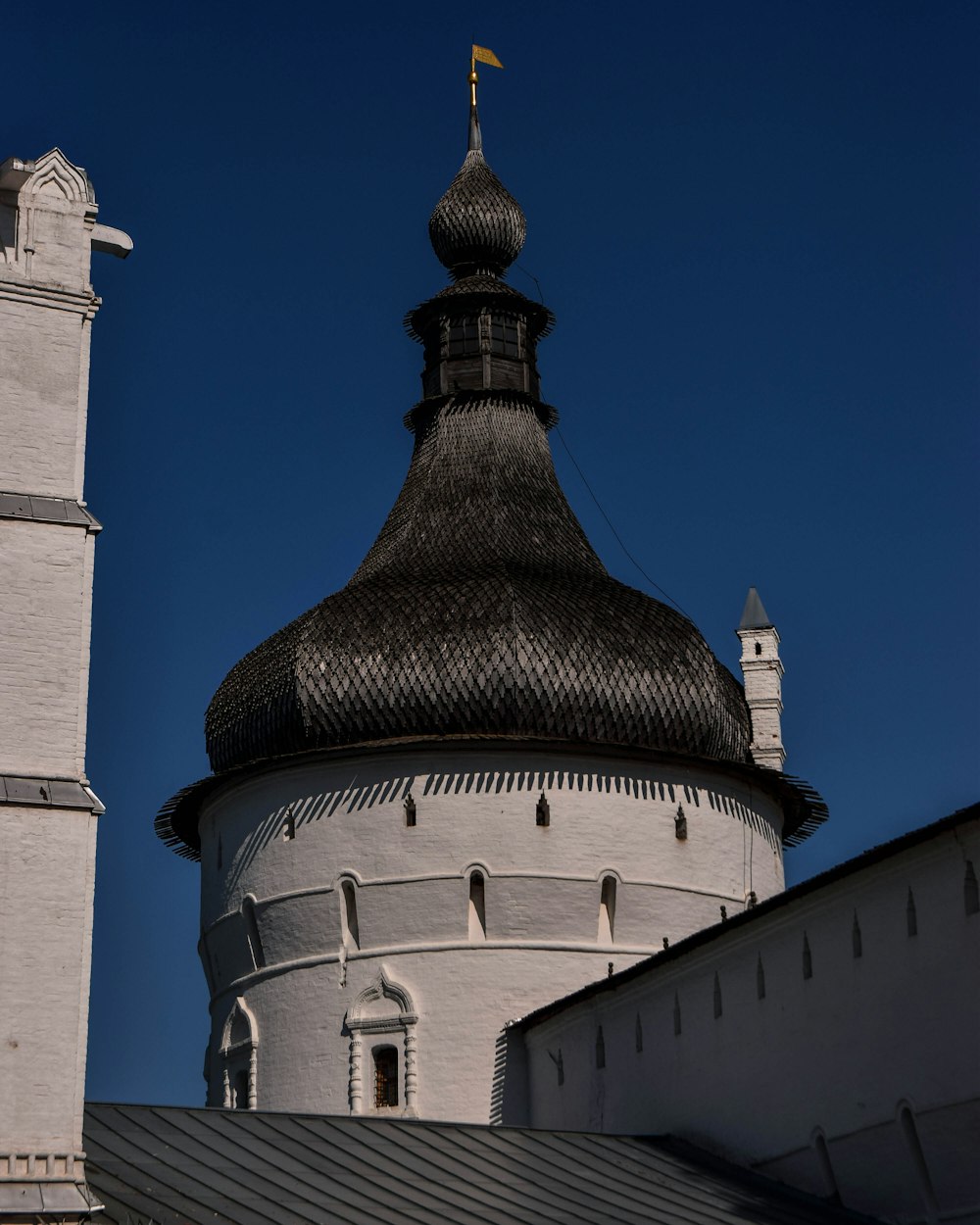 a tall white building with a black roof