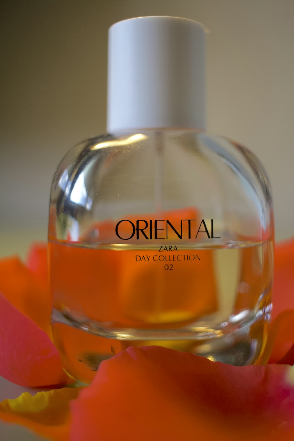 a bottle of oriental perfume sitting on top of a flower