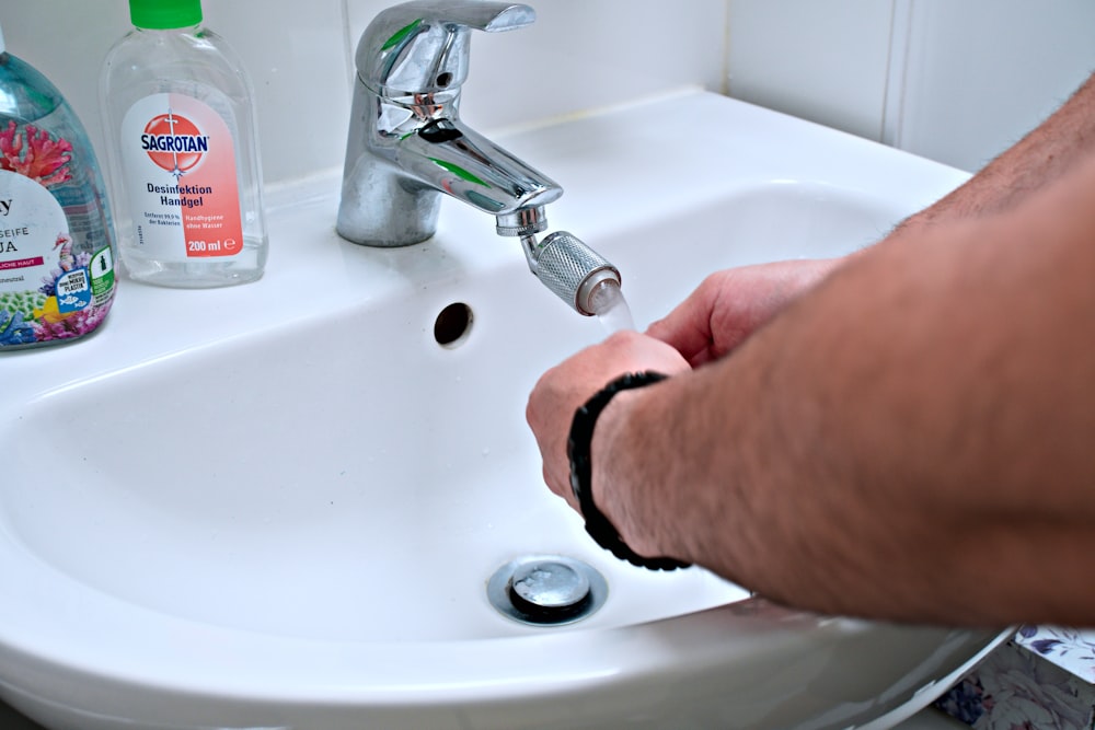 Una persona se está lavando las manos en un fregadero