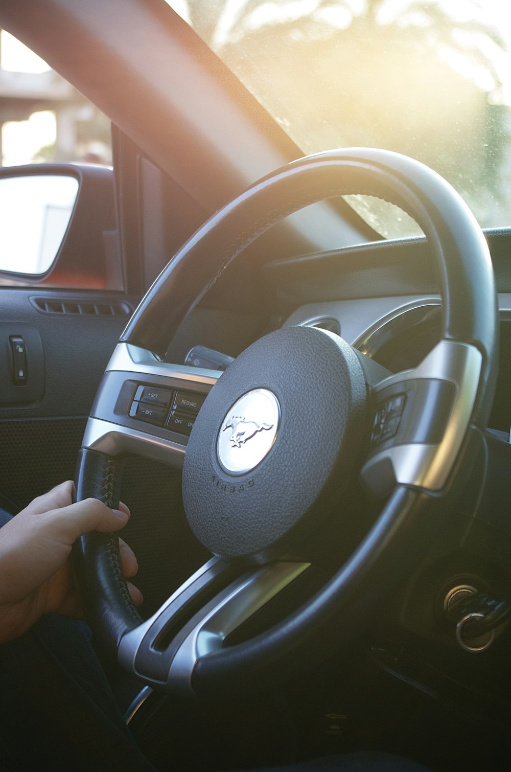 a person holding a steering wheel in a car