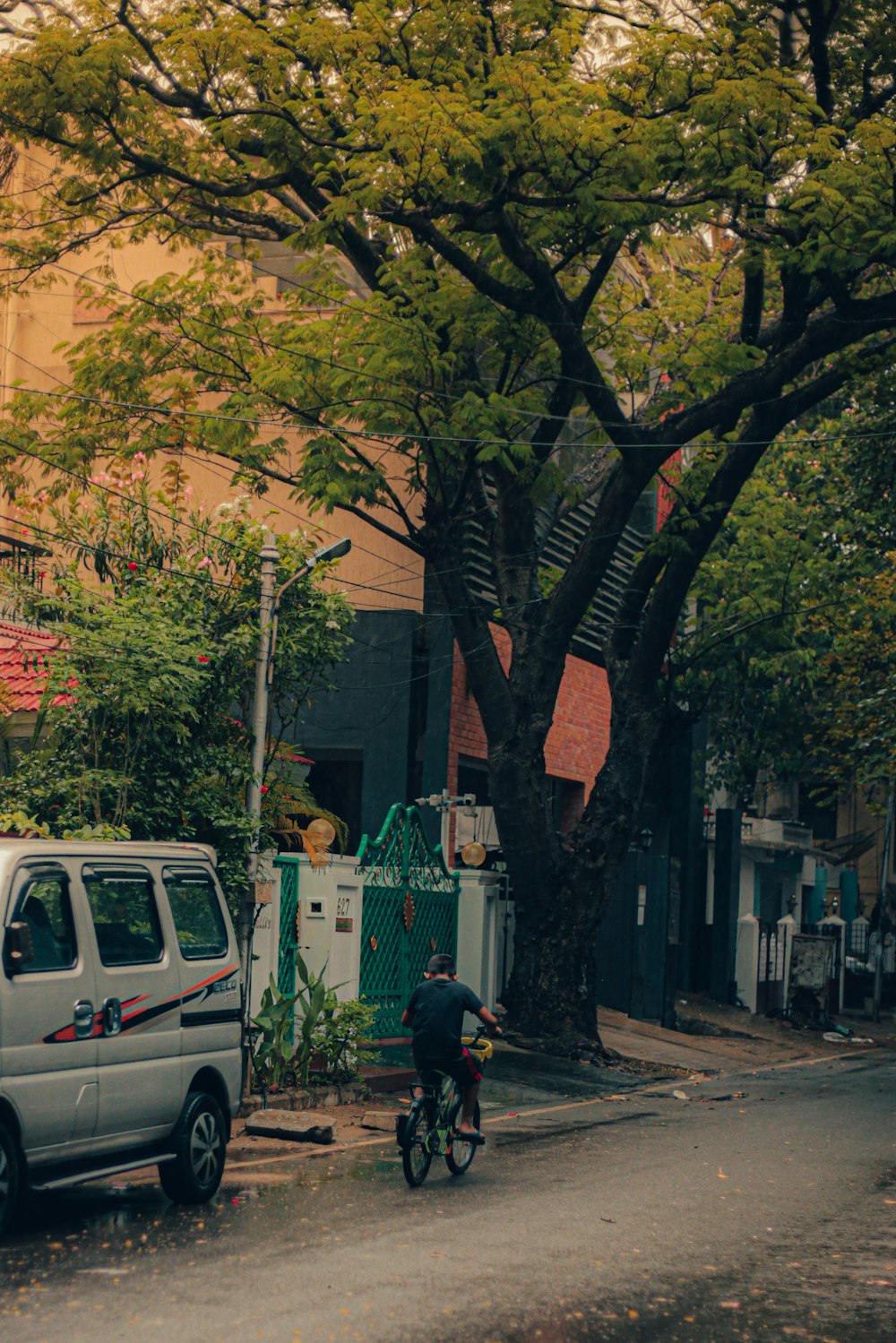 a man riding a bike down a street next to a van