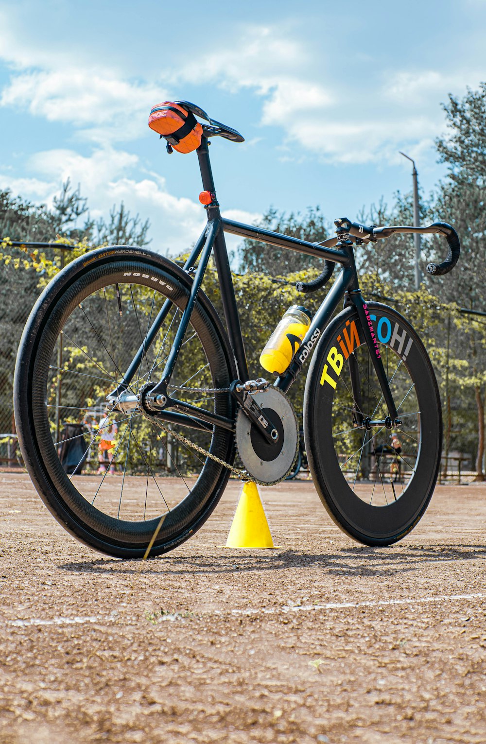 a bicycle leaning against a yellow cone in a park