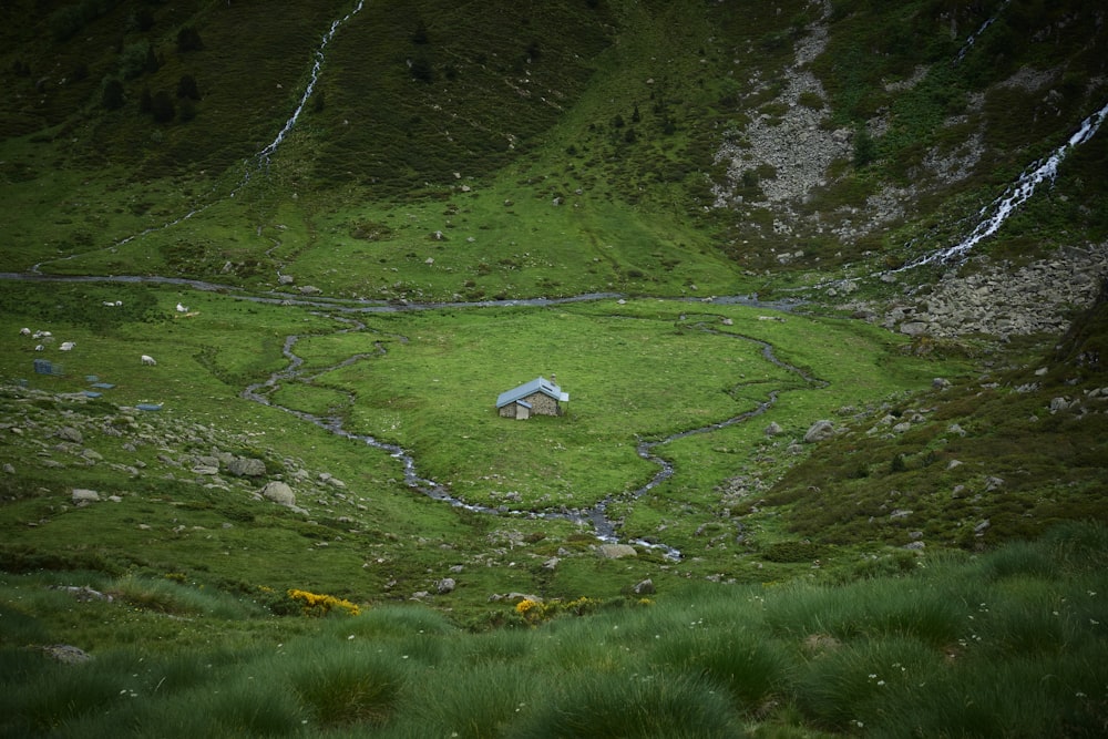 a small house in the middle of a grassy field