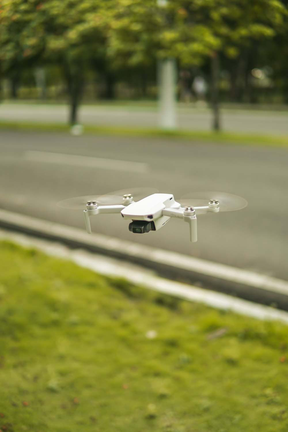 a white remote controlled flying over a street