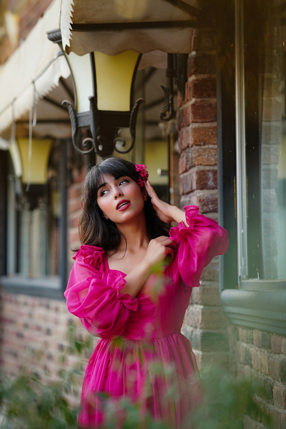 a woman in a pink dress standing outside of a building