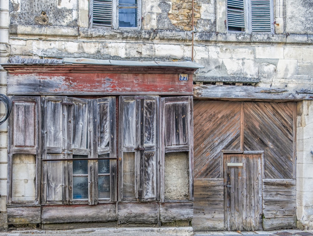 an old run down building with wooden shutters