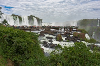 a group of people standing on a bridge over a river