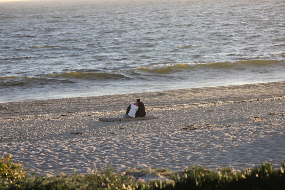 una persona seduta su una tavola da surf sulla spiaggia