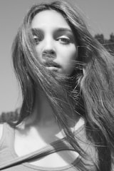 Elegant portrait of a young woman with natural lighting and a white background.