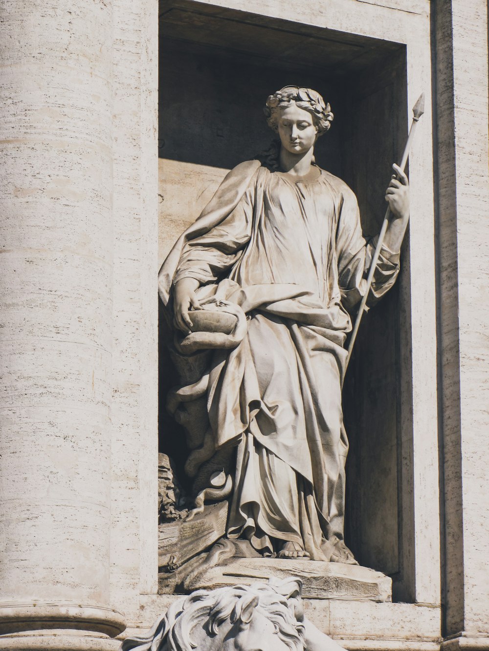 a statue of a man holding a sword in front of a building
