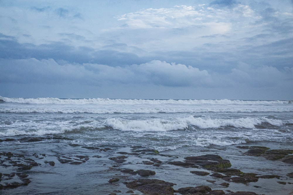 a person standing on a beach with a surfboard