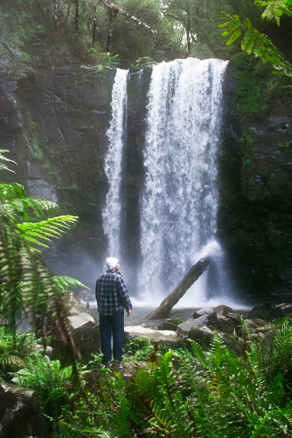 Un uomo in piedi davanti a una cascata