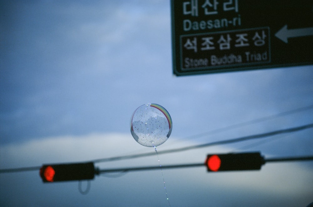 a traffic light with a bubble hanging from it's side