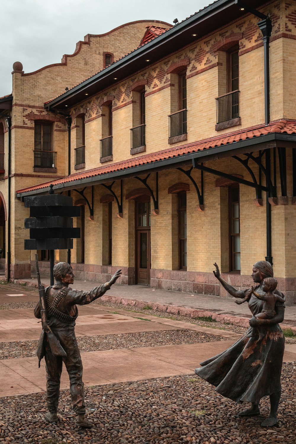 a statue of two people holding a sign in front of a building