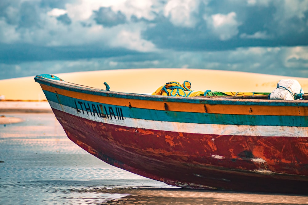 um barco sentado em cima de uma praia de areia