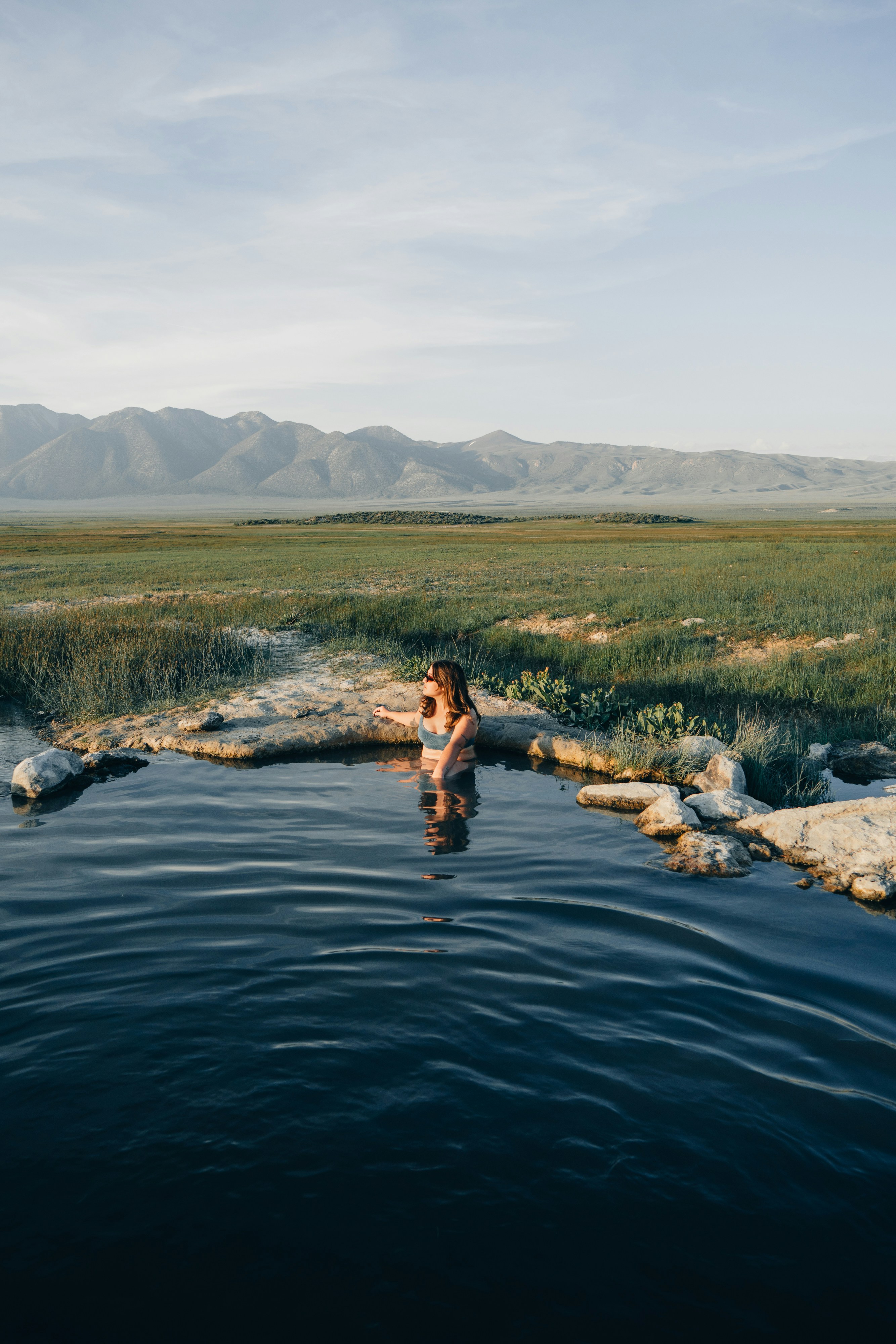 a woman in a body of water with mountains in the background