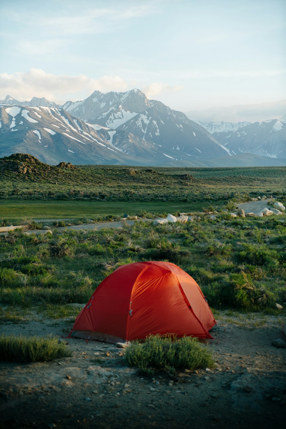 una tenda rossa seduta in mezzo a un campo