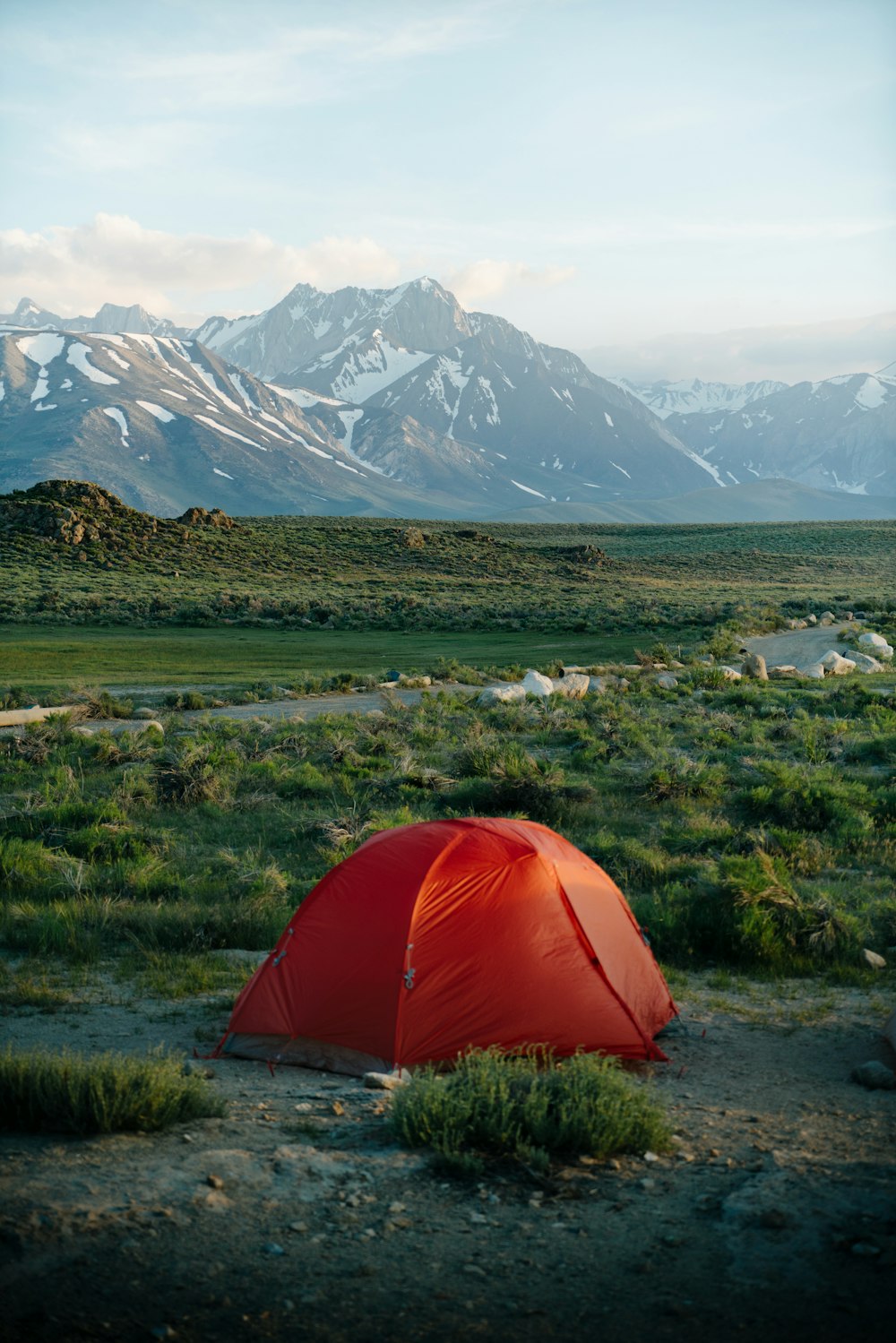 a red tent sitting in the middle of a field