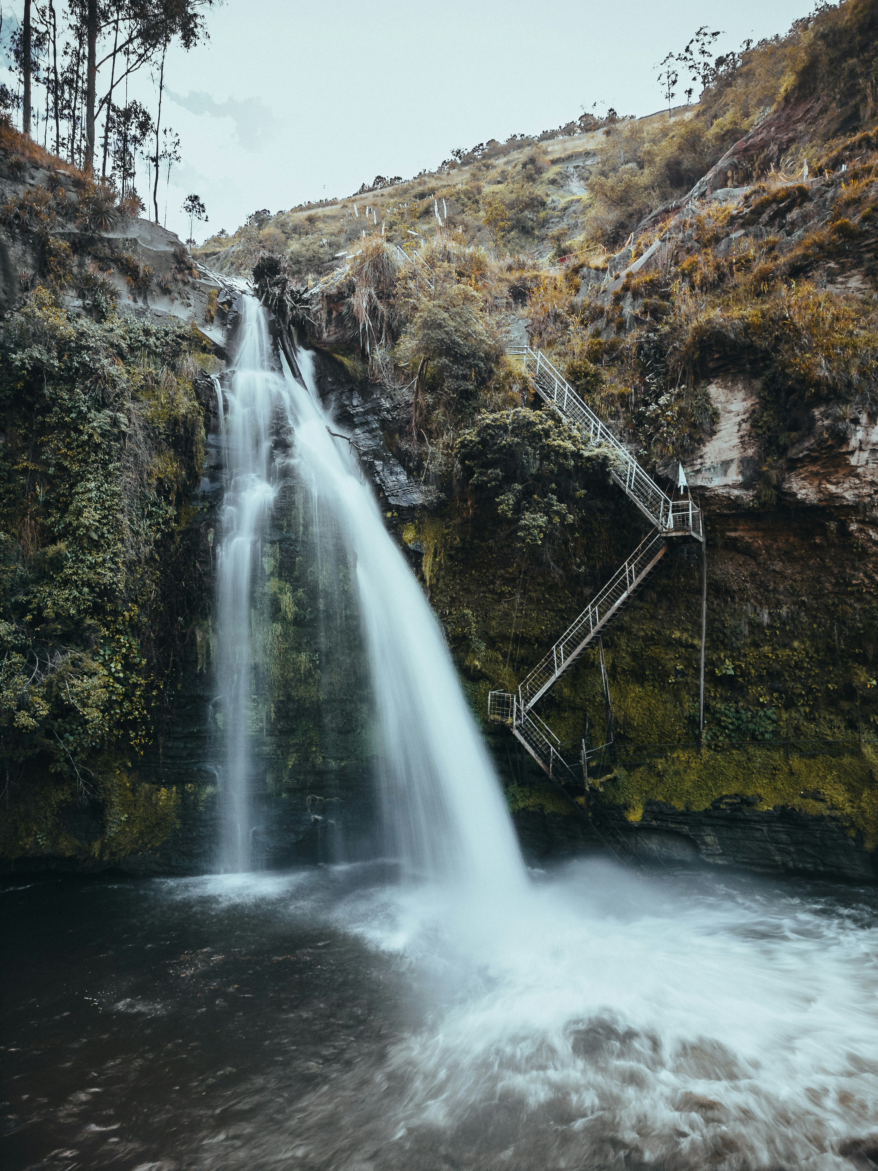 a waterfall with stairs leading to it