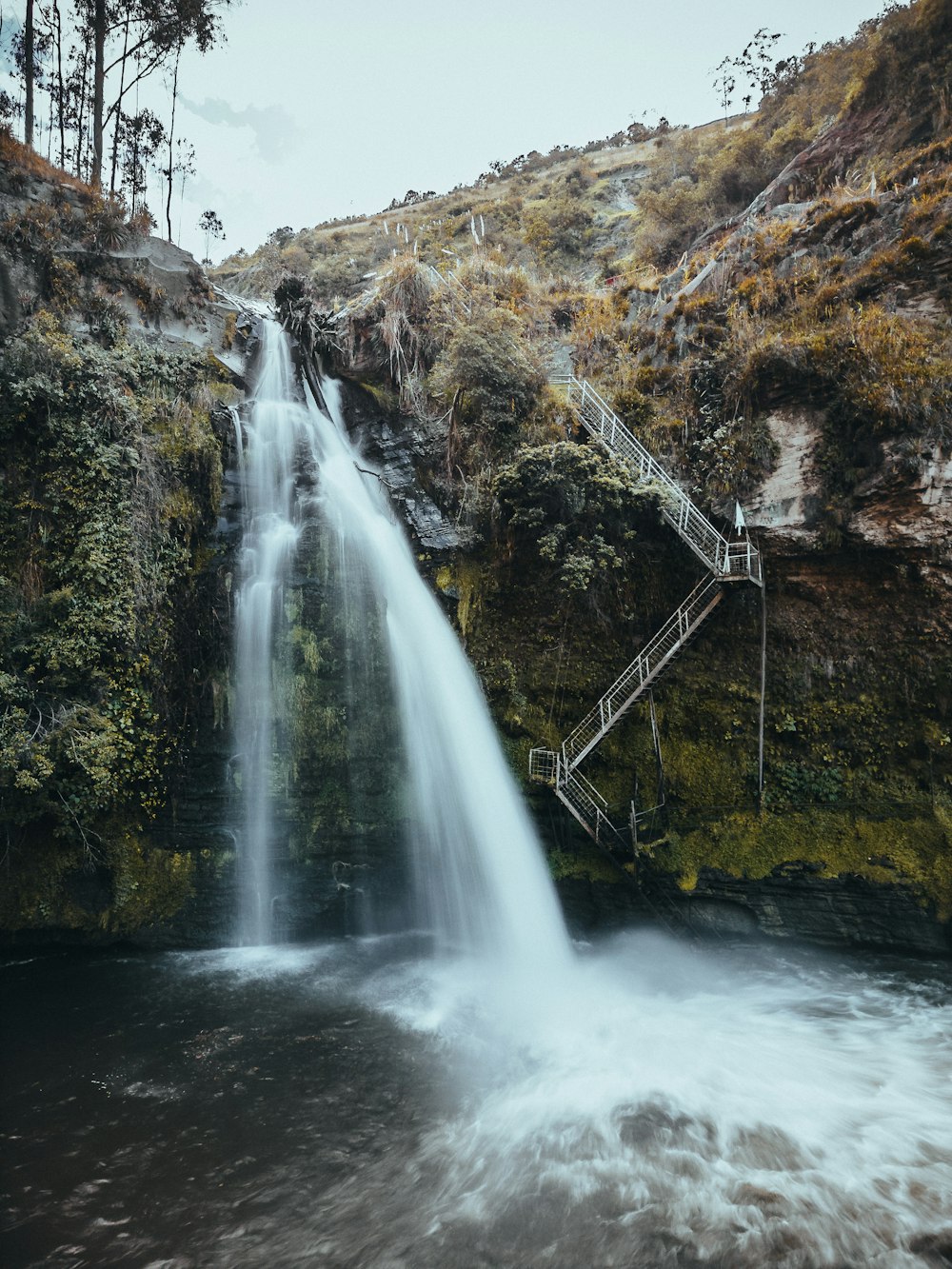 a waterfall with stairs leading to it