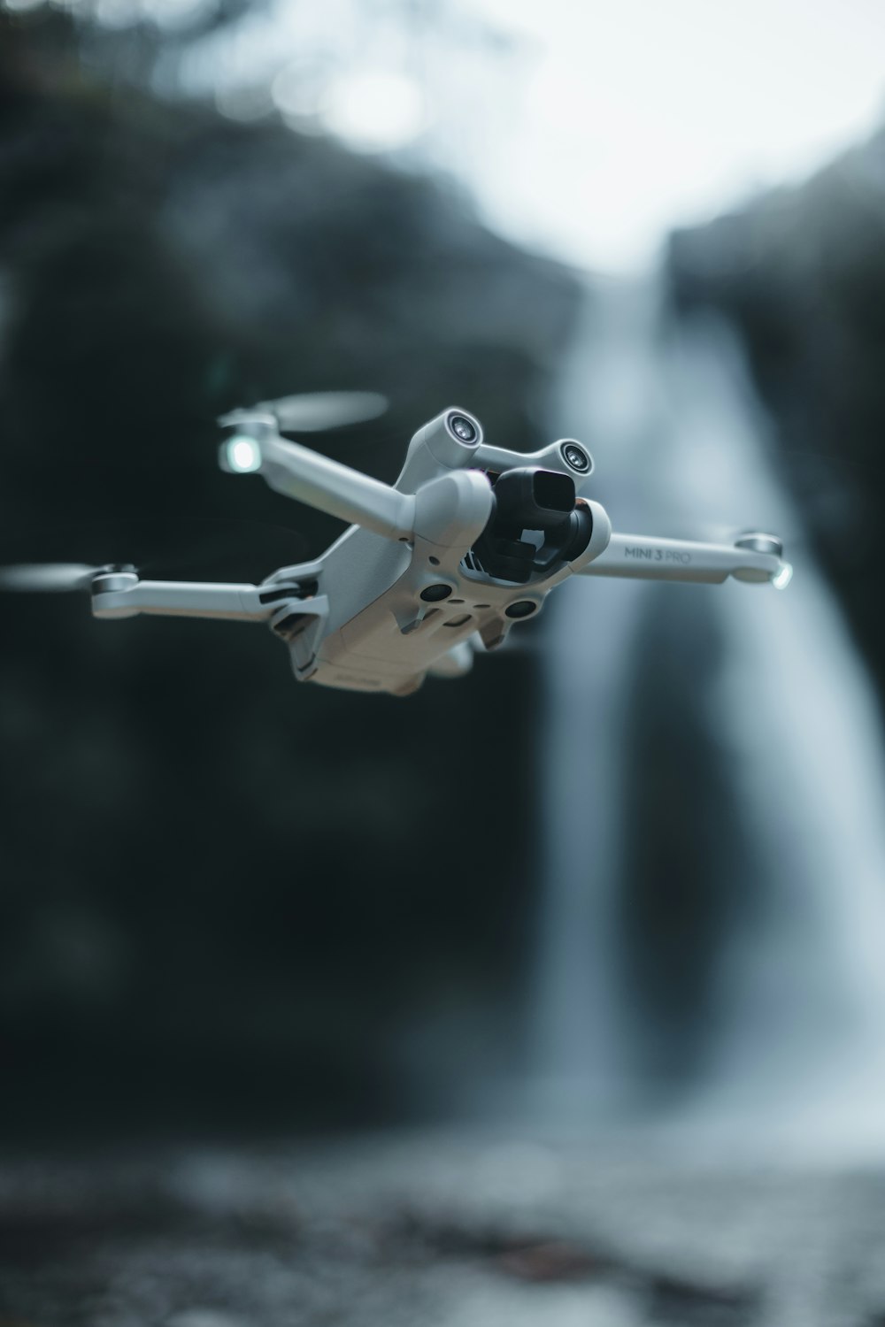 a remote controlled airplane flying over a waterfall