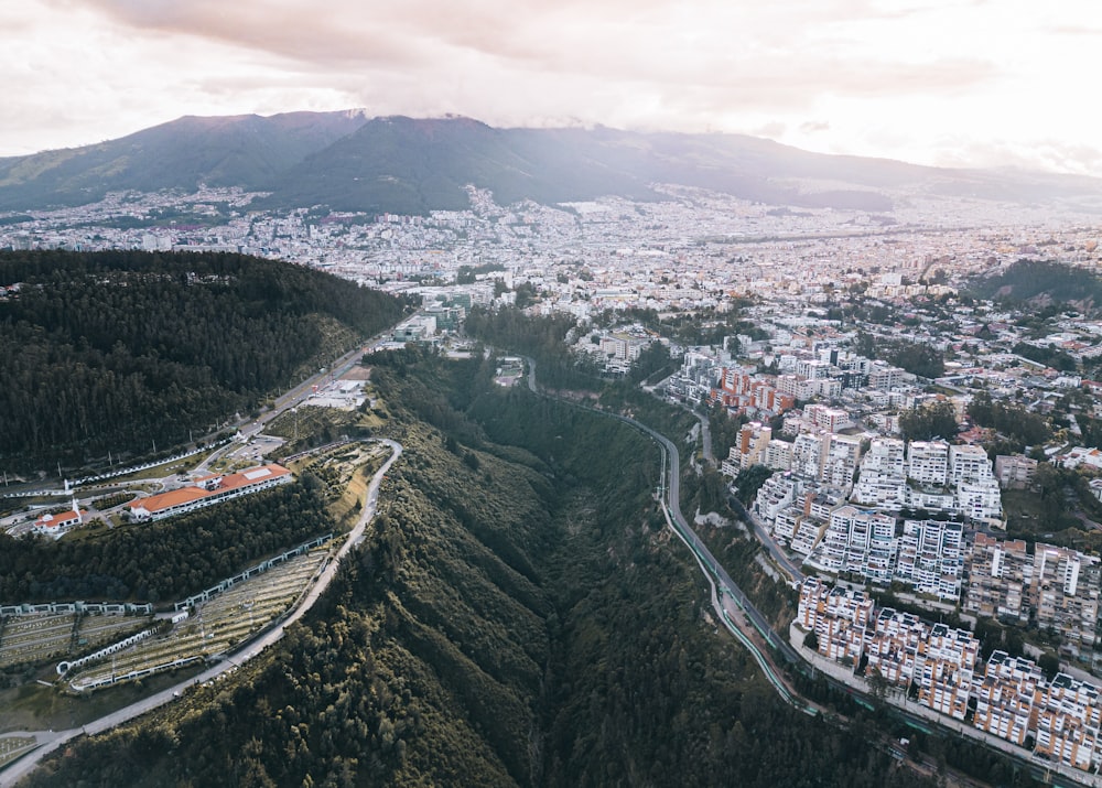 an aerial view of a city with mountains in the background