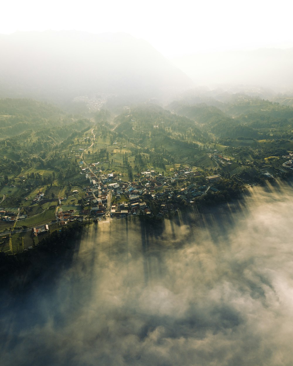 an aerial view of a town surrounded by clouds
