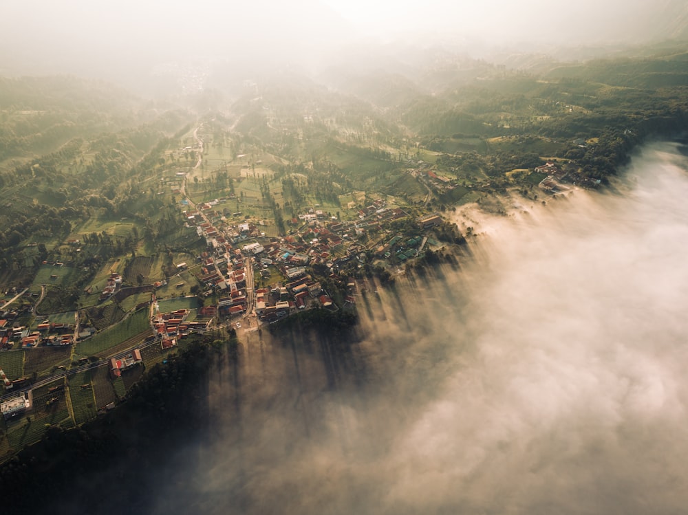 an aerial view of a town surrounded by clouds