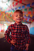 Close-up of a cheerful boy showing off his vibrant batik shirt with playful patterns.