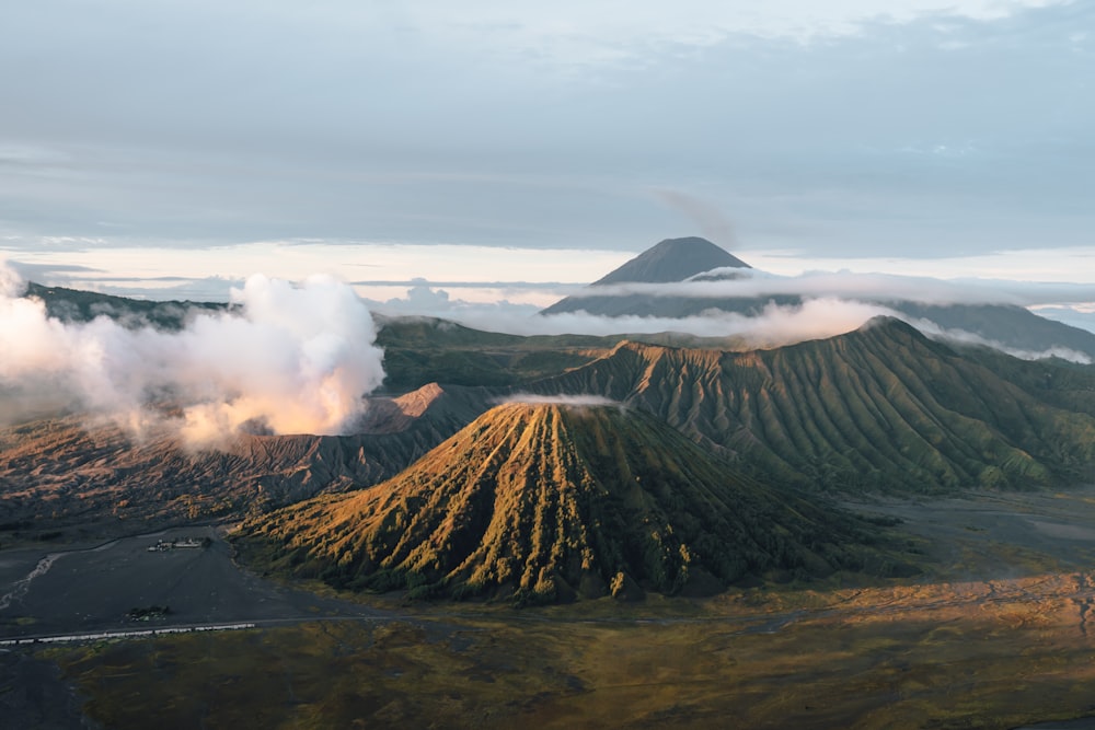 an aerial view of a volcano with clouds coming out of it