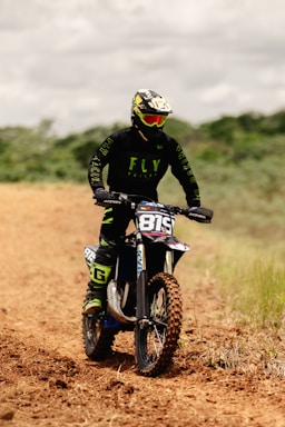 a man riding a dirt bike on a dirt road