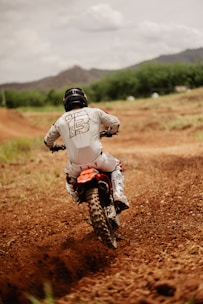 Close-up of a dirt bike rider navigating a rugged off-road trail.