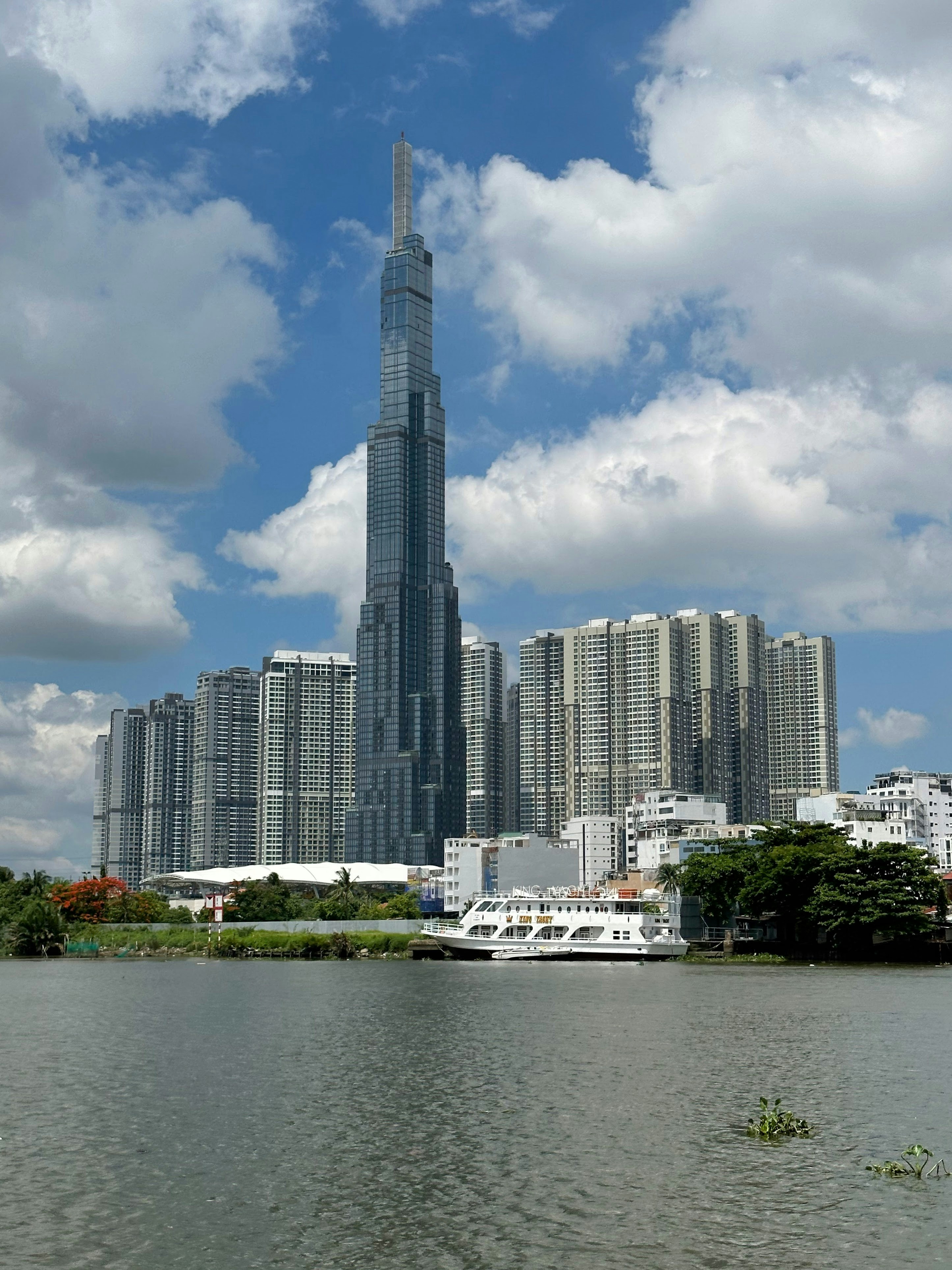 Luxury high-rise residential tower with glass facade overlooking river