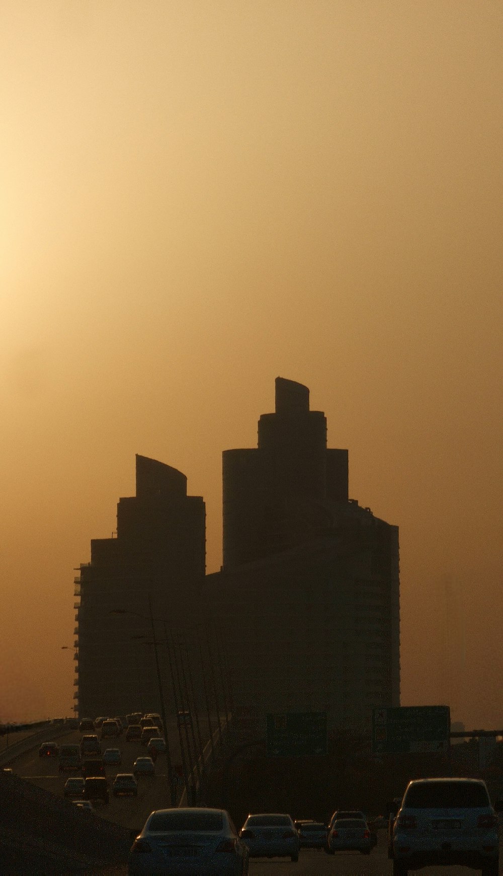 the sun is setting over a city with tall buildings