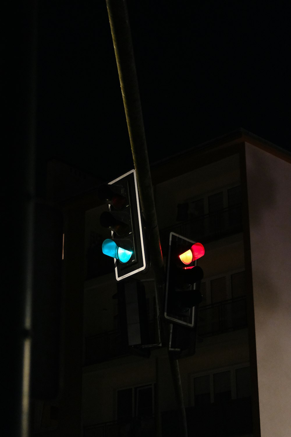 Un semáforo con un edificio al fondo