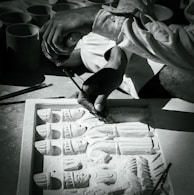 An artisan carefully carving wood details during a live demonstration.
