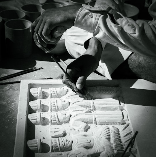 A skilled craftsman shaping a granite monument in a workshop.