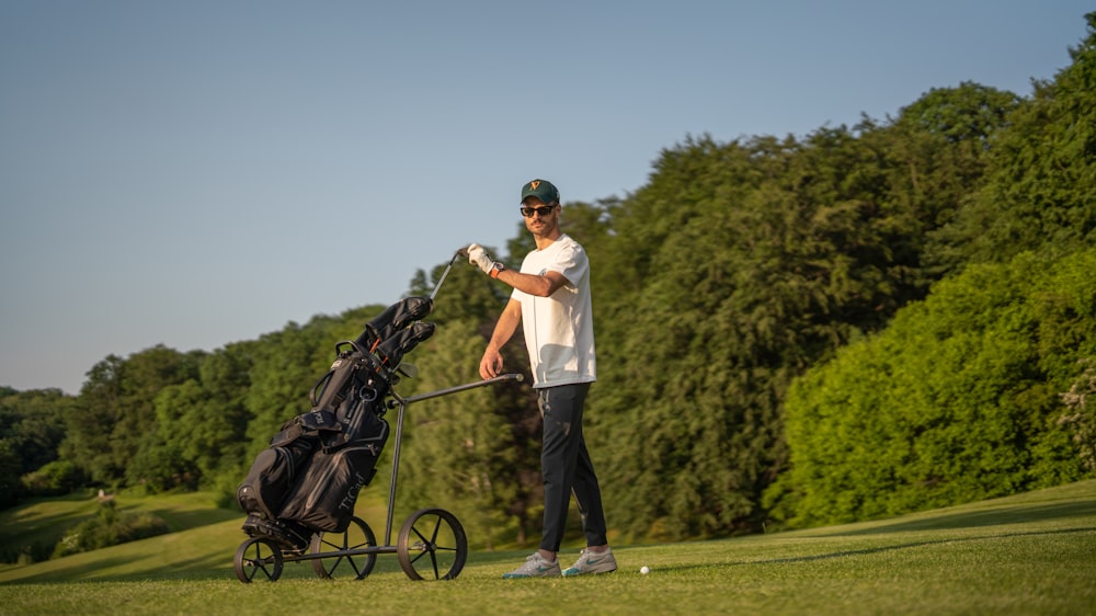 a man holding a golf club next to a golf cart