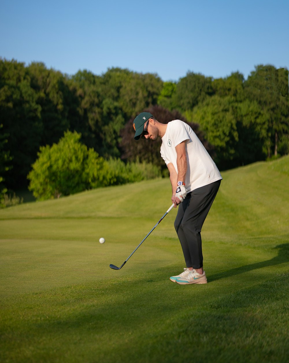 um homem jogando golfe em um campo de golfe