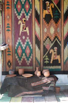 A vibrant western outfit laid out on a wooden table with hand-thrown pottery beside it.