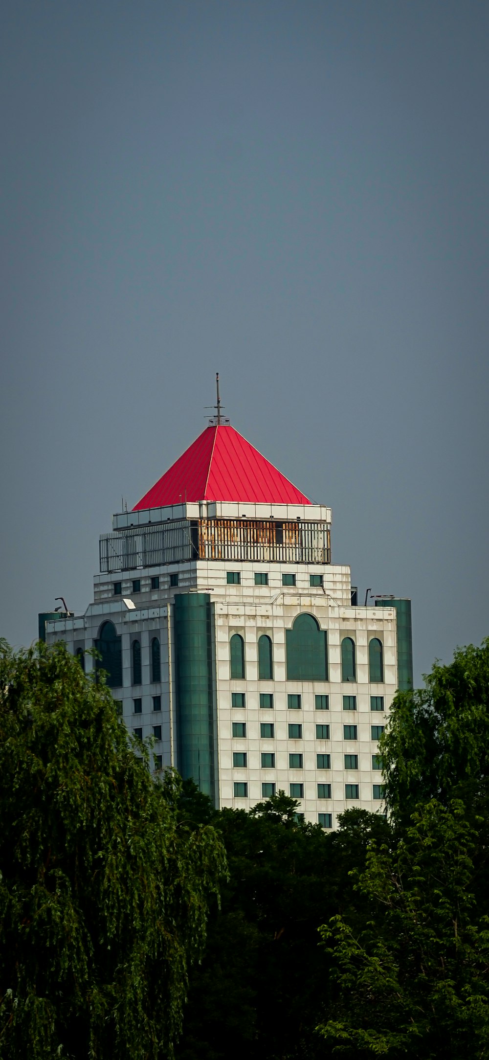 Un edificio alto y blanco con un techo rojo
