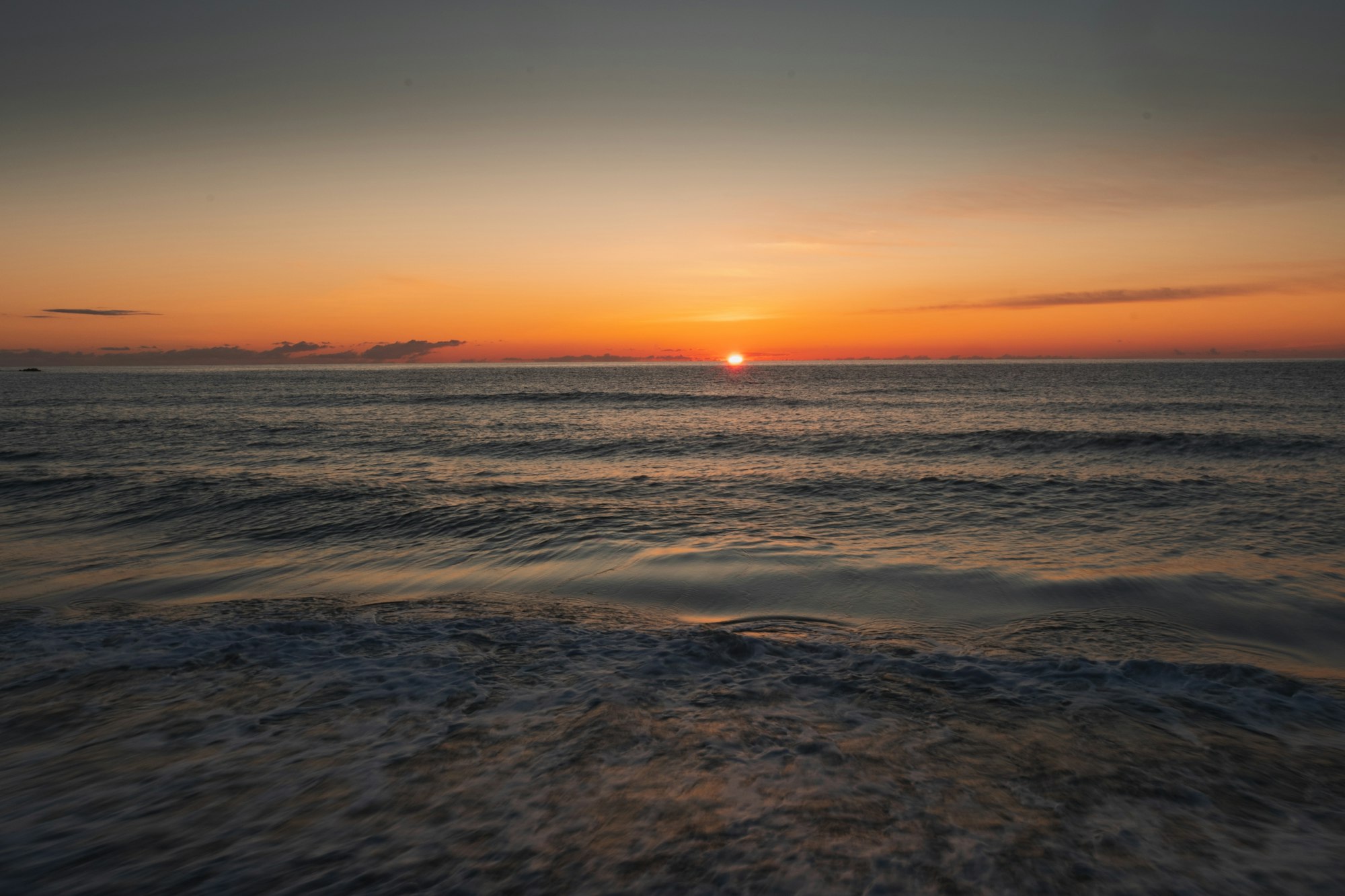 The sun rises above the horizon. A beautiful sunrise at the coast of Corsica in France.