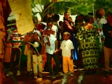 An outdoor scene showing descendants sharing stories and laughter under the shade of large trees